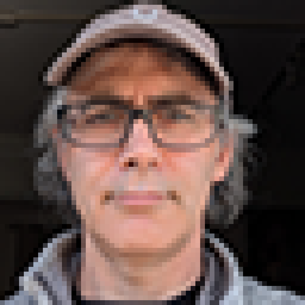 low resolution portrait of a man wearing black glasses and a grey hat